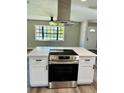 Modern kitchen island with stainless steel range and white cabinets at 1632 Western Rd, South Daytona, FL 32119