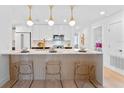 Modern kitchen with a breakfast bar, white cabinets and gold fixtures at 1795 Walker Ave, Winter Park, FL 32789