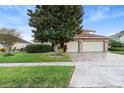Two-story house with a large tree and a brick facade at 2626 Raccoon Run Ln, Orlando, FL 32837