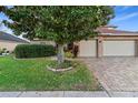 Brick house with two-car garage, landscaping, and a paved driveway at 2626 Raccoon Run Ln, Orlando, FL 32837
