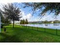 Backyard with a lake view, grassy area, and a black metal fence at 3312 Reedy Glen Dr, Kissimmee, FL 34758