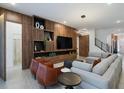 Modern living room with sectional sofa, wood feature wall, and large TV at 5937 High Seas Dr, Orlando, FL 32821