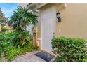 White front door entrance with landscaping and exterior lighting at 8547 Leatherleaf Ln, Orlando, FL 32827