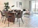 Bright dining area with a wood table and six gray chairs at 8863 Cabot Cliffs Dr # 104, Davenport, FL 33896