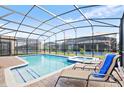 Screened-in pool and spa with lounge chairs in a backyard setting at 1423 Thunderbird Rd, Davenport, FL 33896