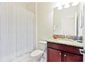 Small bathroom with shower/tub combo, granite countertop, and colorful shower curtain at 1423 Thunderbird Rd, Davenport, FL 33896