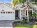 Front view of a house with a three car garage at 1490 Olympic Club Blvd, Champions Gate, FL 33896
