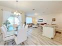 Open concept dining area with glass table and white chairs at 3053 Gatsby St, Kissimmee, FL 34746