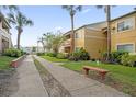 Apartment complex with walkway, landscaping, and bench at 604 Kenwick Cir # 202, Casselberry, FL 32707