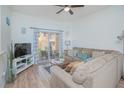 Living room with comfy sectional sofa, sliding door to patio, and wood floors at 121 Palermo St, Davenport, FL 33897