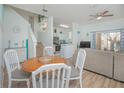 Dining area with round wooden table, white chairs, and kitchen view at 121 Palermo St, Davenport, FL 33897