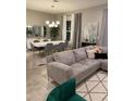 Open living room with gray sectional sofa, geometric rug, and large windows at 14739 Glade Hill Park Way, Winter Garden, FL 34787