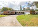 Brick ranch home with a two-car garage and a curved driveway at 2518 Sweetwater Trl, Winter Park, FL 32789