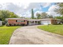 Ranch style brick home with a two-car garage and landscaped lawn at 2518 Sweetwater Trl, Winter Park, FL 32789