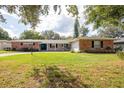 Brick ranch house with a two-car garage and lush green lawn at 2518 Sweetwater Trl, Winter Park, FL 32789