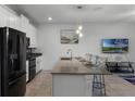 Modern kitchen with island, stainless steel appliances and white cabinets at 4285 Quote St, Kissimmee, FL 34746