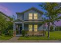 Two-story house with blue exterior, stone accents, and landscaped lawn at night at 6848 Little Blue Ln, Harmony, FL 34773