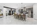Modern kitchen with gray cabinets, marble floors and island with seating at 18357 Mowry Ct, Orlando, FL 32827