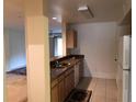 Galley kitchen with granite countertops and light wood cabinets at 474 S Pin Oak Pl # 108, Longwood, FL 32779