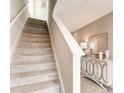 Elegant staircase with neutral carpeting and modern handrail at 3475 Sandalwood Isle Way, Ocoee, FL 34761