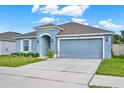 Newly built home with light blue exterior, two-car garage, and well-manicured lawn at 3417 Yarian Dr, Haines City, FL 33844