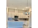 Modern kitchen featuring white cabinets, an island, and stainless steel appliances at 1541 Heritage Pl, Oviedo, FL 32765