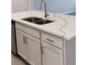 Kitchen island with white cabinets and a large quartz countertop at 1541 Heritage Pl, Oviedo, FL 32765