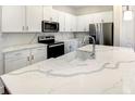 Modern kitchen with white cabinets, quartz countertops, and stainless steel appliances at 1541 Heritage Pl, Oviedo, FL 32765