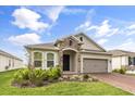House exterior showcasing a beautiful ranch-style home with stone accents and a two-car garage at 1554 Outback W Rd, St Cloud, FL 34771
