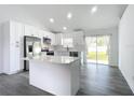 Modern kitchen with white cabinets, a large island, and stainless steel appliances at 1452 3Rd Ave, Deland, FL 32724