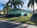 Side view of single-story home showcasing its teal exterior and landscaping at 345 Reserve Dr, Davenport, FL 33896