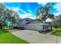Two-car garage with a long driveway and lush landscaping at 6893 Hidden Glade Pl, Sanford, FL 32771