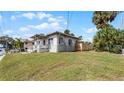 Side view of a single-story home with a grassy lawn and wooden fence at 131 Mitchell Pl, Daytona Beach, FL 32118