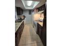 Galley kitchen with dark cabinets and white appliances at 2546 Lemon Tree Ln # 4, Orlando, FL 32839