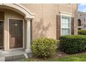 Building entry with brown door, columns, and shrubbery at 14304 Fredricksburg Dr # 420, Orlando, FL 32837
