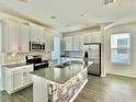 Modern kitchen with white cabinets and island at 1652 Cross Prairie Pkwy, Kissimmee, FL 34744