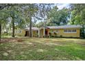 House exterior showcasing a yellow facade and tree-lined yard at 209 Ne Triplet Dr, Casselberry, FL 32707