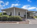 Well-maintained manufactured home with covered carport and landscaping at 905 Polo Park Blvd, Davenport, FL 33897