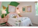 Charming bedroom with pink and green accents, featuring a comfy bed and decor at 2509 Raghav Trail Rd, Tavares, FL 32778