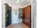Front entry with dark door, wood cabinet, and string lights at 821 Pine Shores Cir, New Smyrna Beach, FL 32168