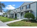 Row of two-story townhomes with light gray exterior and landscaped lawns at 506 Rainbow Springs Loop, Groveland, FL 34736