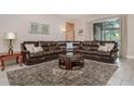 Spacious living room with brown leather sectional sofa and large TV at 5160 Oakbourne Ave, Davenport, FL 33837
