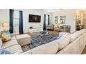 Living room featuring a sectional sofa, large TV, and comfortable armchairs at 1522 Moon Valley Dr, Davenport, FL 33896