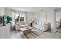 Bright living room with comfy sofas, a coffee table, and a large window at 3821 Rory Pond Ct, Lakeland, FL 33811