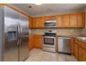 Kitchen with wood cabinets, stainless steel appliances, and granite countertops at 404 Banyon Tree Cir # 200, Maitland, FL 32751