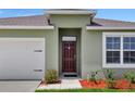 House entrance with a dark brown door and white garage door at 1117 Star Ruby Ln, Winter Haven, FL 33880