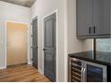 Modern condo entryway with wood flooring, gray doors, and a wine cooler at 155 S Court Ave # 1912, Orlando, FL 32801