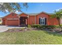 Two-story house with orange exterior and landscaping at 1221 Glendora N Rd, Kissimmee, FL 34759