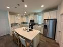 Modern kitchen featuring white cabinets, stainless steel appliances, and an island at 15121 Pigeon Plum Ln, Winter Garden, FL 34787