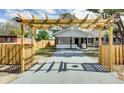 Quaint cottage with a pergola, gate, and wooden fence at 280 Westwood Ave, Winter Haven, FL 33880